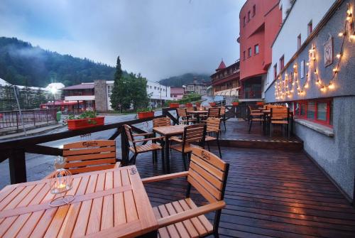 a row of wooden tables and chairs on a balcony at Vila Teleconstructia in Slănic-Moldova