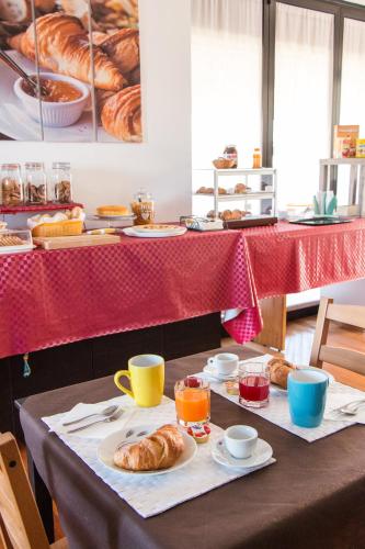a table with croissants and cups of coffee and pastries at Villa Boninsegna - Wine Enoteca Verdi - in Castel d'Azzano
