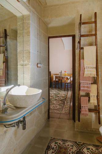 a bathroom with a sink and a room with a table at Borgoterra in Martano