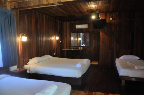 a hotel room with two beds and a television at Joe Fisherman Inn in Pangkor