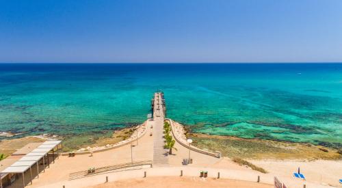 a clock tower on the beach next to the ocean at Fig Tree Beach Houses in the heart of Protaras in Protaras