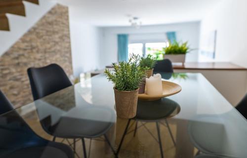 a dining table with chairs and a candle on it at Fig Tree Beach Houses in the heart of Protaras in Protaras