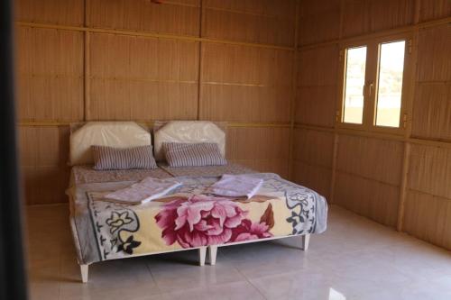 アル・ハムラにあるjabal shams moonの花が飾られたベッドのある寝室