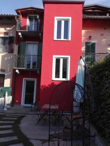 a red building with a bench in front of it at eden in Cannobio