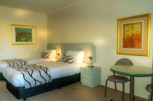 ein Hotelzimmer mit einem Bett und einem Tisch in der Unterkunft Deniliquin Country Club Motor Inn in Deniliquin