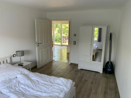 a white bedroom with a bed and a mirror at Quartier Usedom in Ostseebad Karlshagen