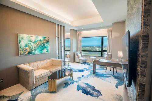 a living room with a couch and a table and a desk at Grand Hotel Lili in Taitung City