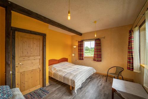 Schlafzimmer mit einem Bett, einem Fenster und einer Tür in der Unterkunft Jaunie Pātari in Bernāti