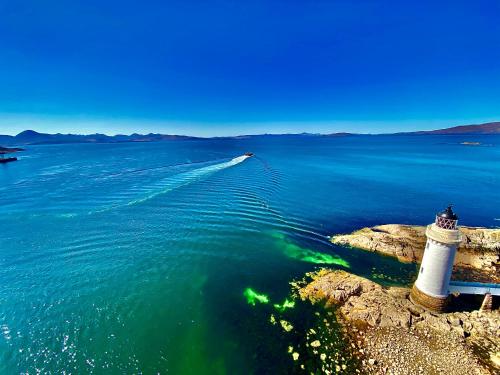 a lighthouse on the shore of a body of water at The Lodge Dunrowan in Kyle of Lochalsh