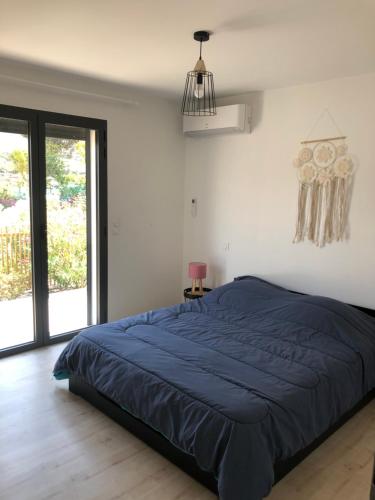 - un lit dans une chambre avec une couette bleue dans l'établissement Villa Célestine, à Calvi
