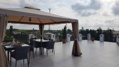 a patio with tables and chairs under a large umbrella at Twins in Anaklia