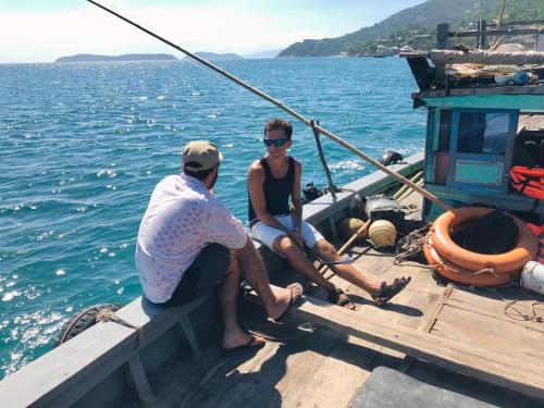 a man and a woman sitting on a boat in the water at Nhi Lo Home Stay in Tân Hiệp