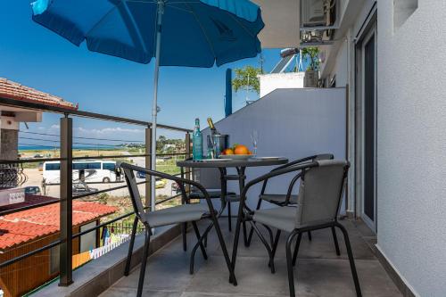 ネア・カリクラティアにあるHBA apartments 2 Vergia beachのテーブルと椅子と傘のあるバルコニー