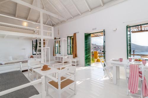 a room with white furniture and large windows at Atlantis Houses in Halki