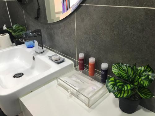 ein Badezimmer mit einem weißen Waschbecken und einem Spiegel in der Unterkunft Lux Hotel Room in Damansara Perdana in Damansara Perdana