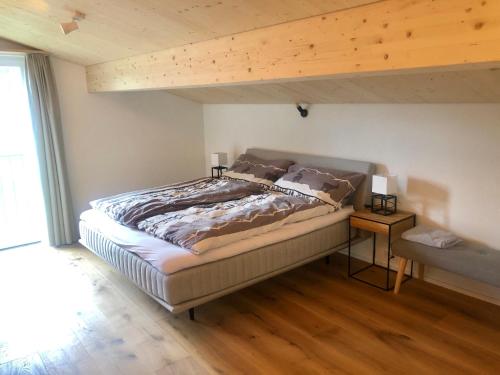 1 dormitorio con 1 cama grande y suelo de madera en Studio Mattawaldstrasse 17A en Davos