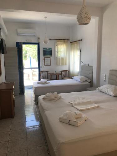 um quarto com 2 camas e uma sala de estar em Romantika em Platis Gialos, Mykonos