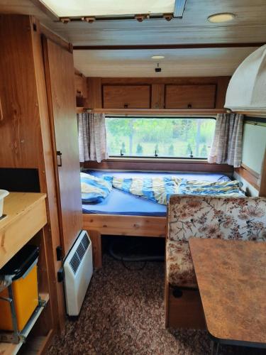 a small bedroom in an rv with a bed and a desk at ADAM 23 in Werder