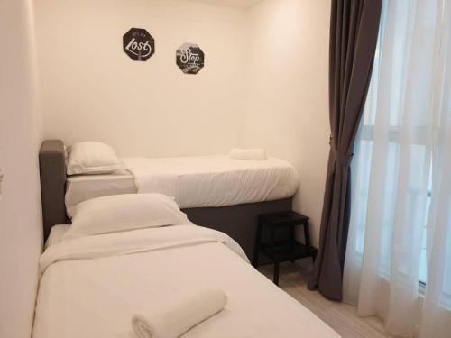 a room with three beds and a window at FLYPOD - Blue Sky Apartment 4-5pax , Sutera Avenue in Kota Kinabalu