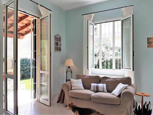 una sala de estar con sofá y un perro. en Villa la Casetta con giardino a 30 m dal mare, en San Bartolomeo al Mare