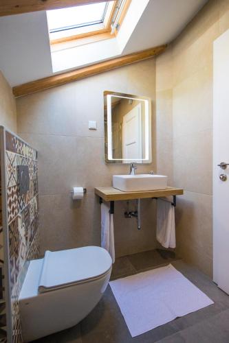 a bathroom with a sink and a toilet and a mirror at House Maro in Brsečine