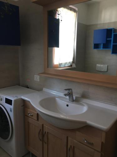 Un baño con lavabo y lavadora. en Apt 23 Residence delle Rose, en Peschiera del Garda