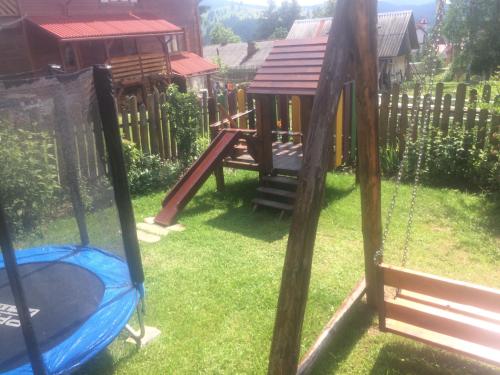 - une aire de jeux avec balançoire dans une cour dans l'établissement Mini Cottage, à Yablunytsya