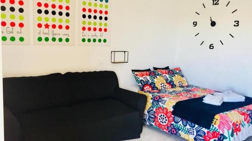 1 dormitorio con 1 cama y reloj en la pared en Minerva Sea View Apartment, en Benalmádena
