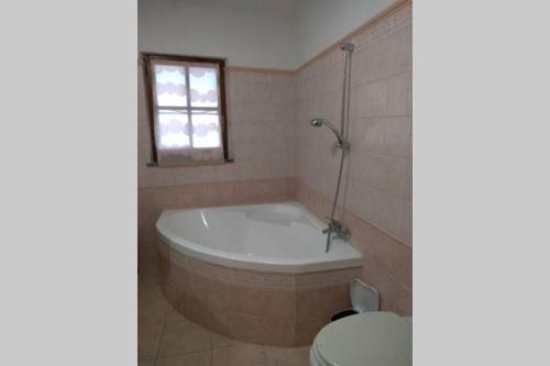 a bathroom with a bath tub and a toilet at Casa vacanza Ligustro appartamento il toro in SantʼAntìoco