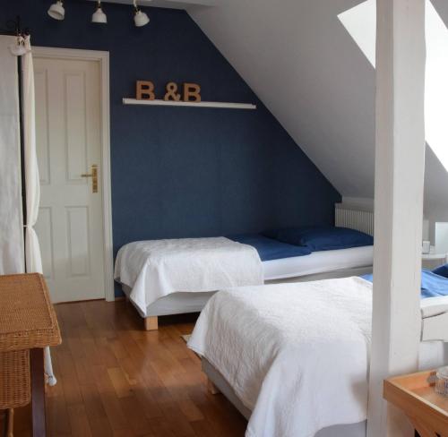 1 dormitorio con 2 camas y pared azul en Bed & Breakfast Freiberg, en Freiberg