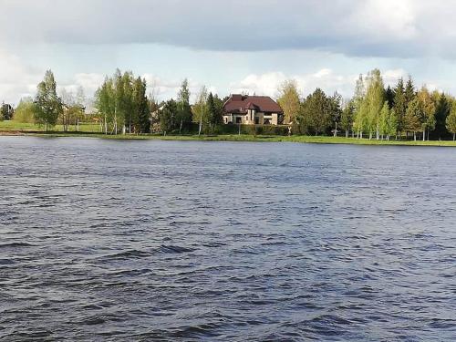 a house on the shore of a large body of water at Ramus poilsis prie Širvintų marių in Širvintos