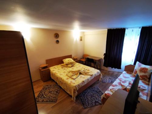 a small room with a bed and a table and chairs at Casa camy in Eforie Nord