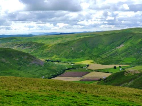 a view of a green valley with fields and mountains at Southpark House in Dumfries