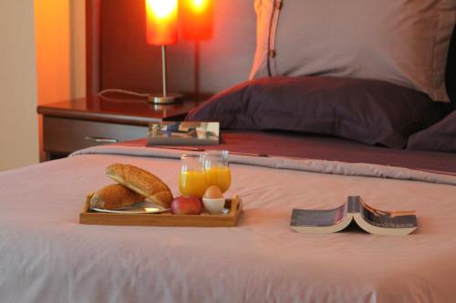 a tray of food and orange juice and bread on a bed at Accommodation Dolcino in Ulcinj