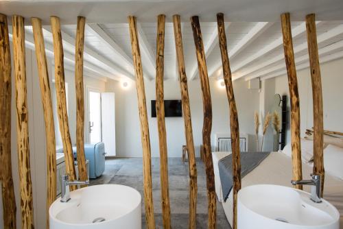 twee wastafels in een kamer met houten palen bij 9 Islands Suites Mykonos in Mykonos-stad