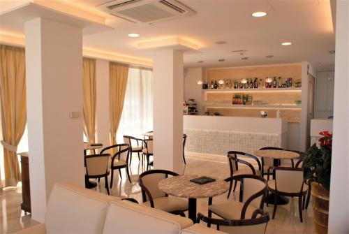 a restaurant with tables and chairs and a bar at Hotel Caesar Paladium in Rimini