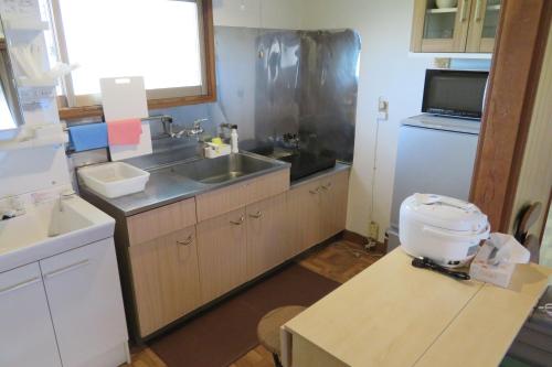 een keuken met een wastafel en een toilet. bij Mizu no Gakko in Shari