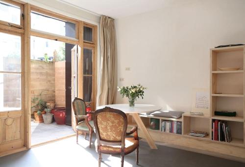 a table and chairs in a room with a window at The Little Townhouse in Amsterdam