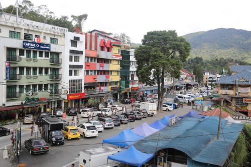 una strada trafficata con auto parcheggiate sulla strada di Camlodge Budget Hotel a Cameron Highlands