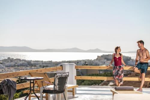 a man and a woman standing on the balcony of a house at Nèsoi Villas Naxos in Naxos Chora