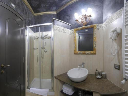 a bathroom with a sink and a shower with a mirror at Antica Dimora Delle Cinque Lune in Rome