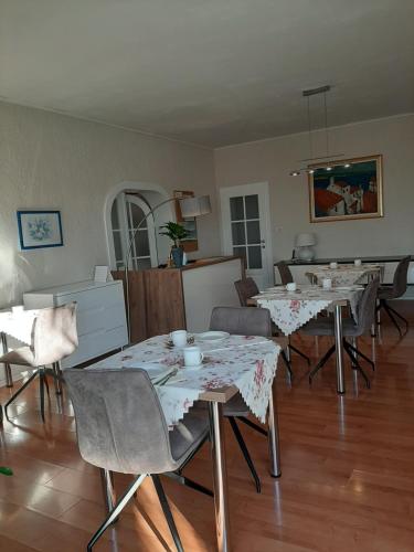 a living room with tables and chairs in it at B&B Eva in Ičići