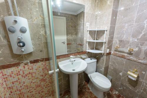 a bathroom with a toilet and a sink and a mirror at Apartamentos Nuevo México C 432 in Calpe