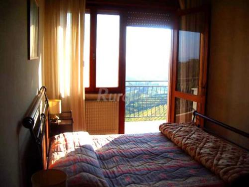 a bedroom with a bed in front of a window at Alla Torre Antica in Ruttàrs