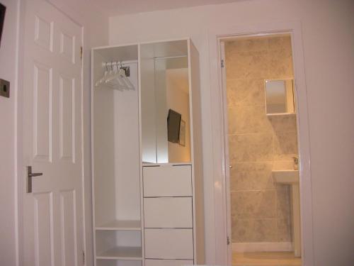 a bathroom with a white closet with a mirror at The Studio Pod, St Andrews in St Andrews