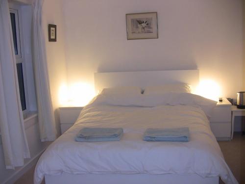 a bedroom with a white bed with two towels on it at The Studio Pod, St Andrews in St Andrews