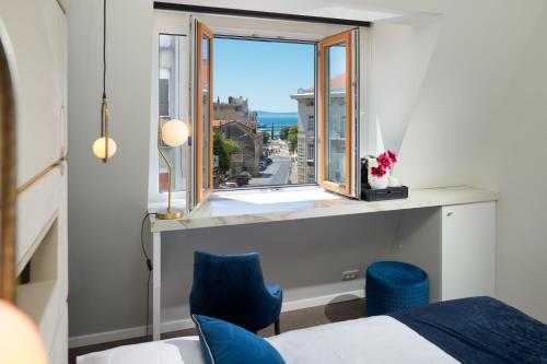 1 dormitorio con ventana y vistas al océano en Flos Luxury Rooms, en Split