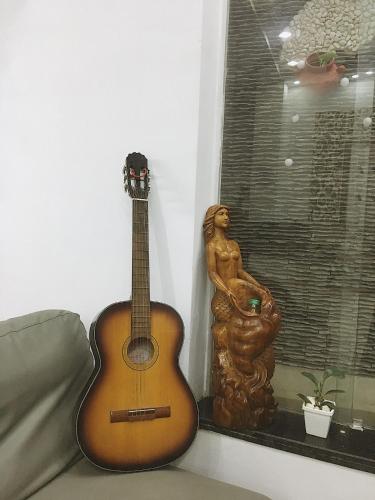 a guitar sitting on a couch next to a window at Hello SaiGon Homestay in Ho Chi Minh City