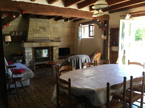 a dining room with a table and a fireplace at Maison Coeur de Brenne in Rosnay