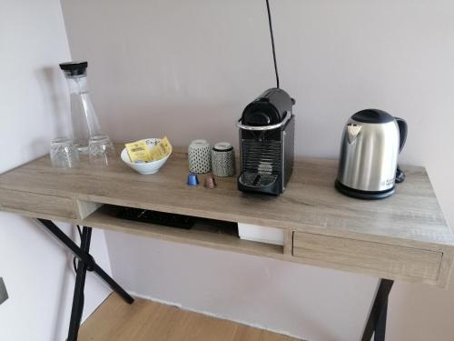 una encimera con cafetera sobre una mesa de madera en La Roseraie, en Stavelot